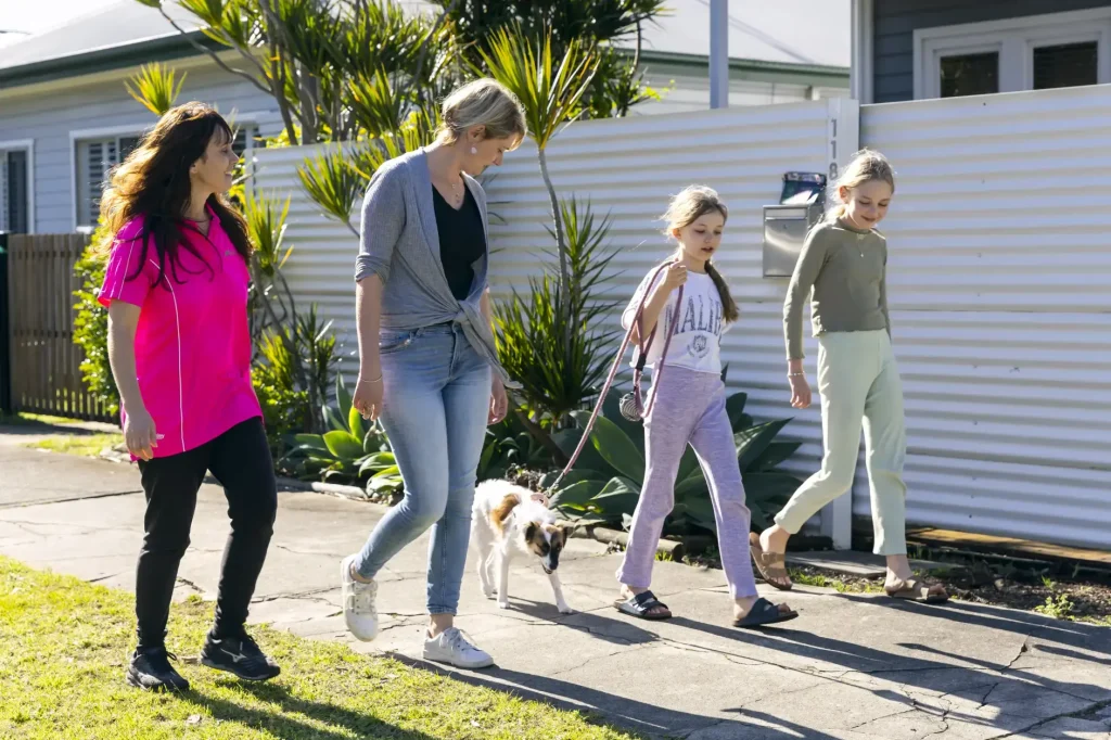 family learning to walk dog on lead